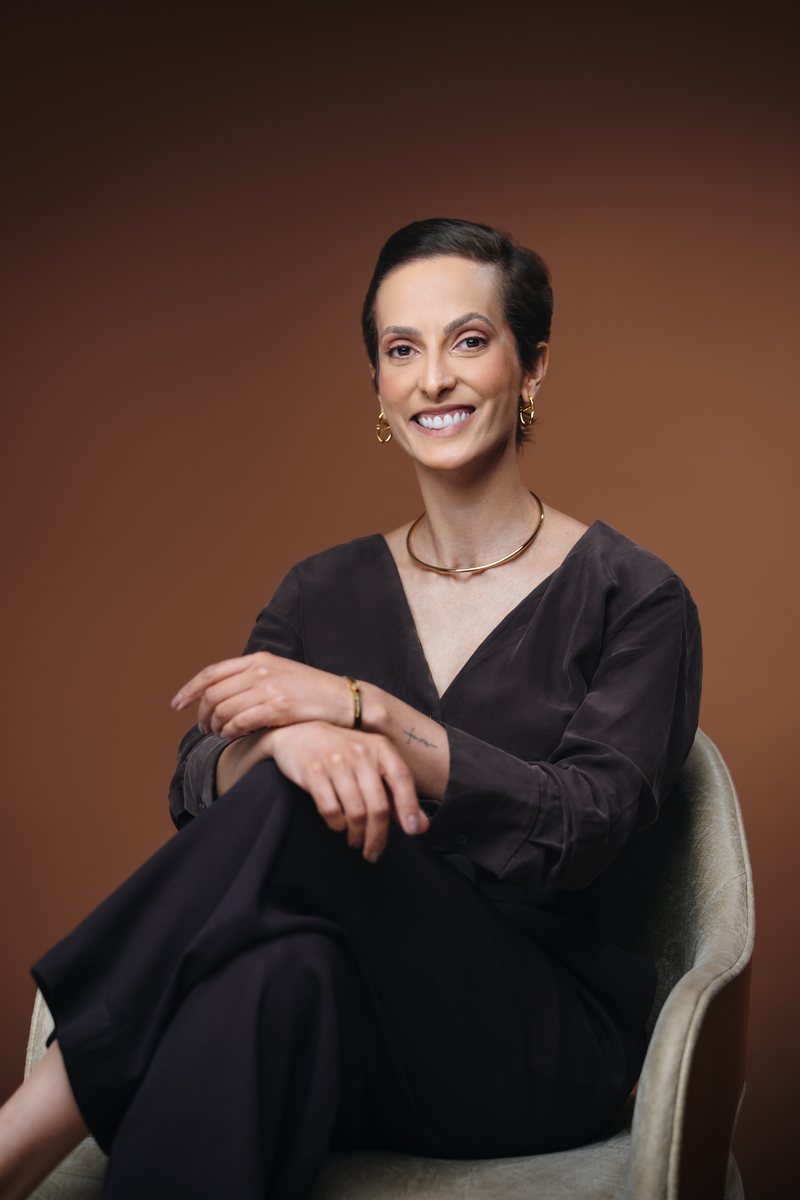 Tatiana Maria, sorrindo, sentada numa poltrona